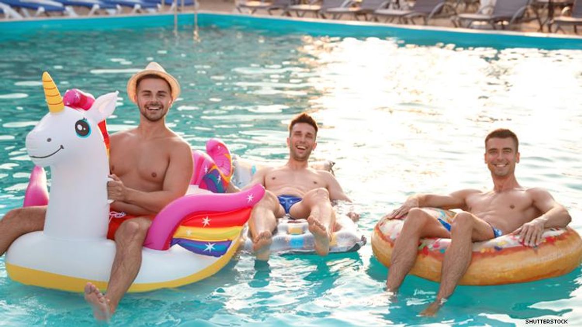 3 men in a pool with unicorn float
