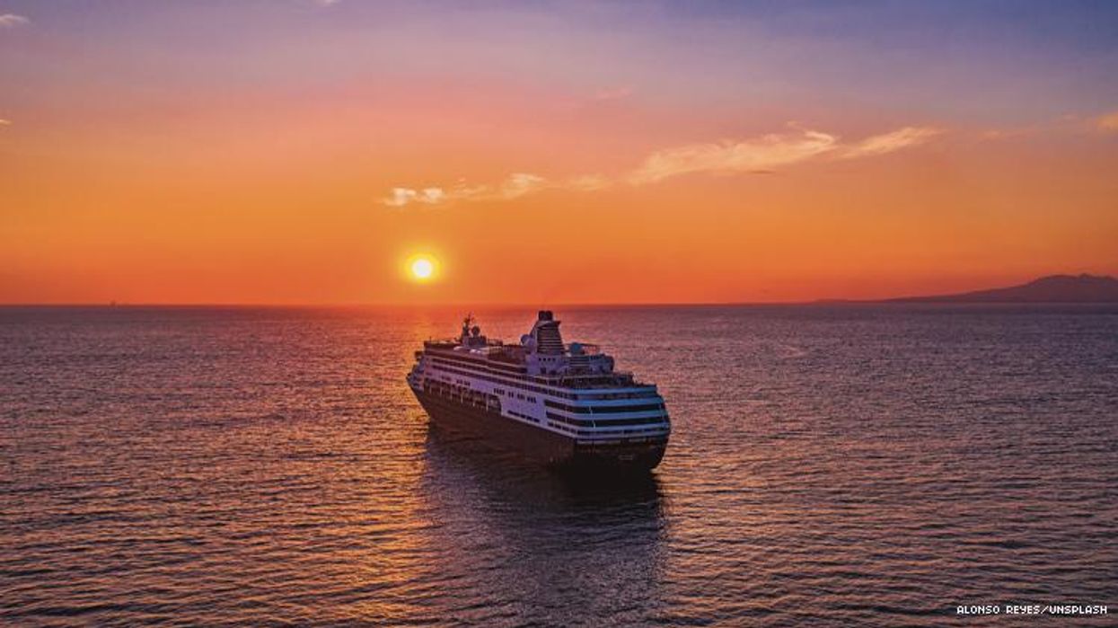 A cruise ship on ocean with rising sun