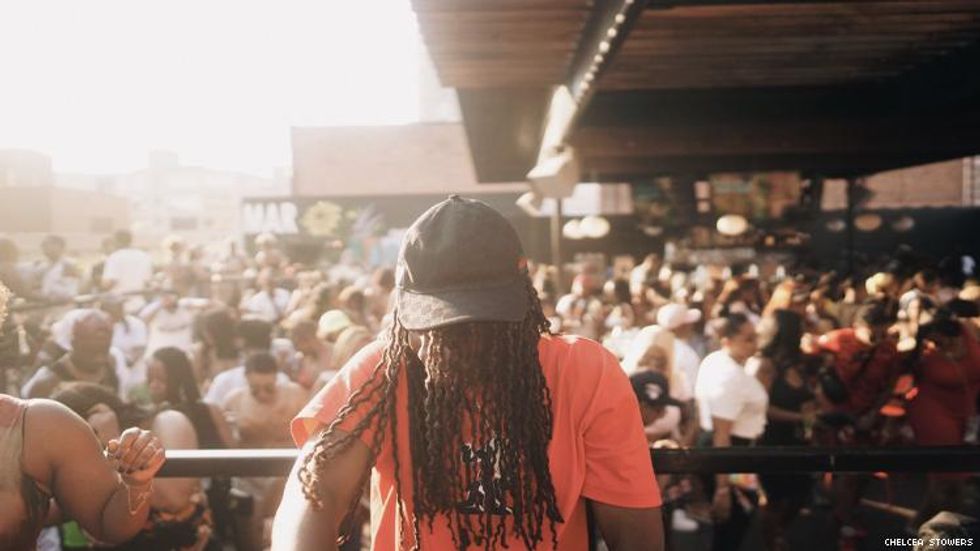 A dj playing for a crowd of women at a Lesbian Social Detroit event