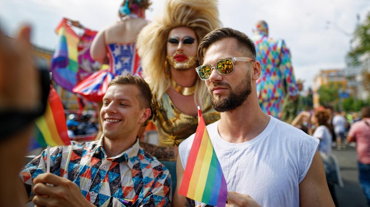 A drag queen and two gay men at a Ukraine Pride