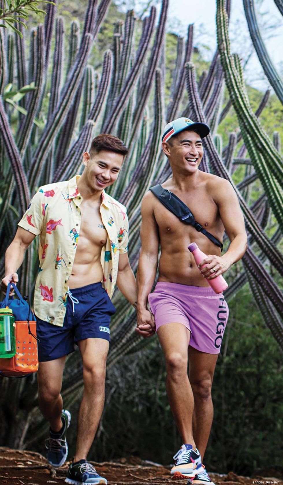A gay couple walk through tall cactuses on Hawaii by Braden Summers
