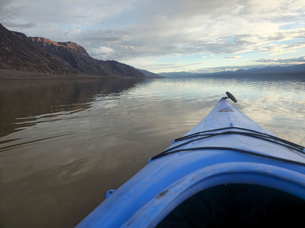 A kayaker on the temporarily filled Lake Manley in Death Valley National Park. Recent rains and flooding created the temporary water body which is six miles long, three miles wide, and only one foot deep