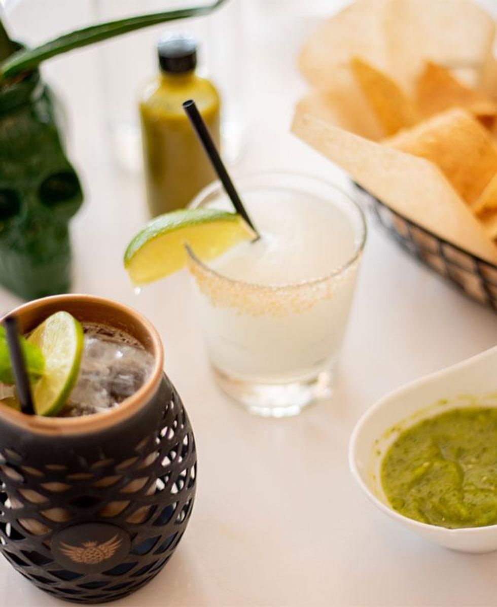 A Margarita next to chips and green salsa