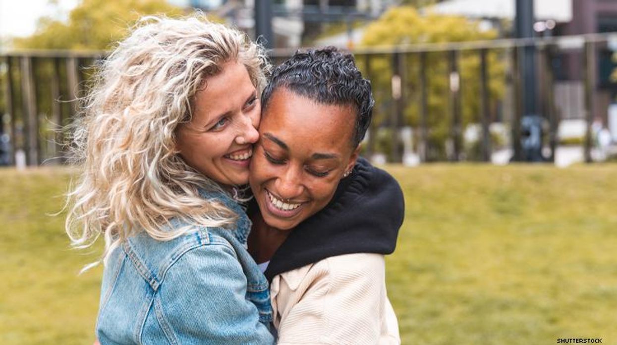 A mixed race lesbian couple embrace in London