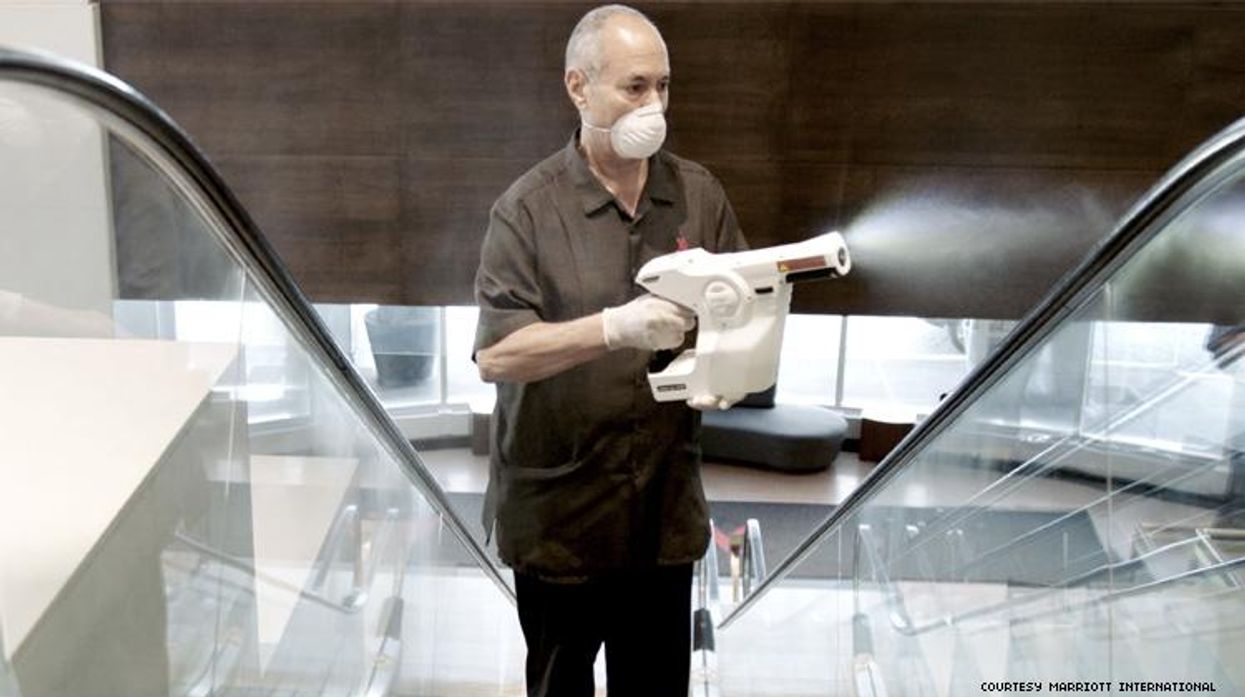 A worker at Marriott uses an electrostatic cleaner