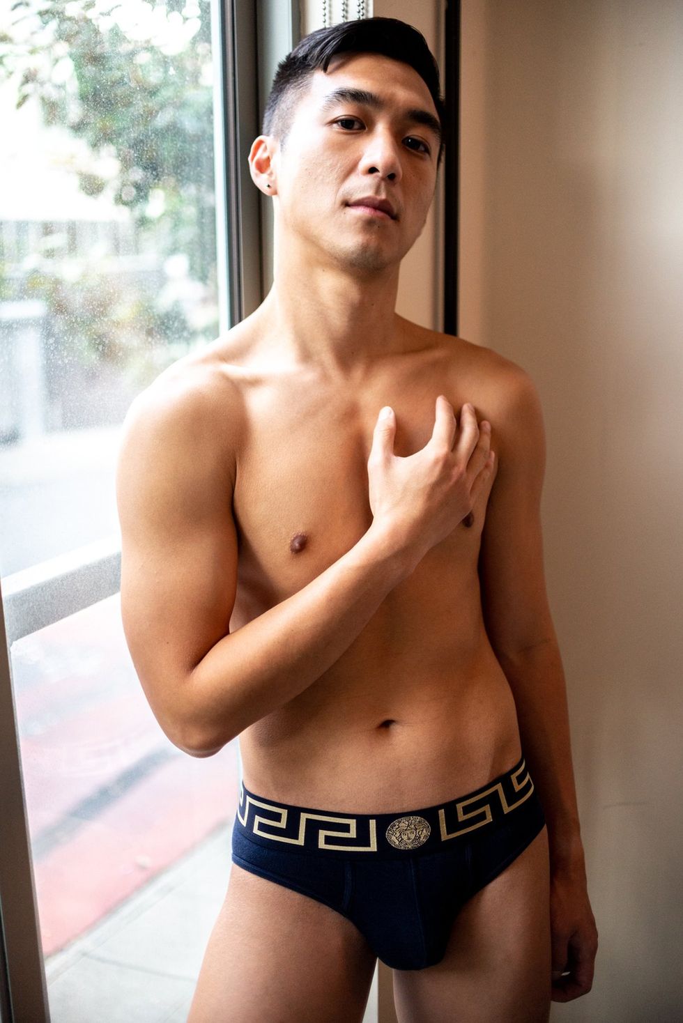 Asian American man shirtless in black underwear