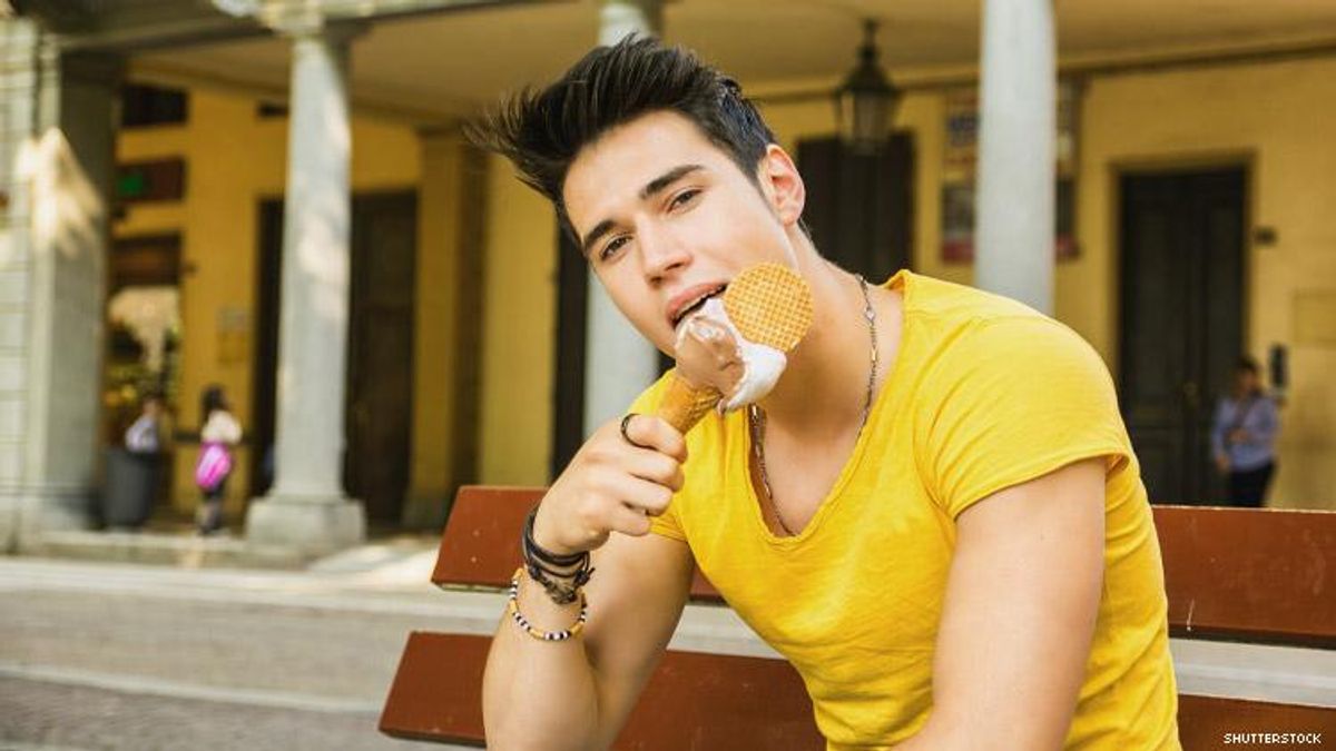 Attractive man licks an ice cream cone