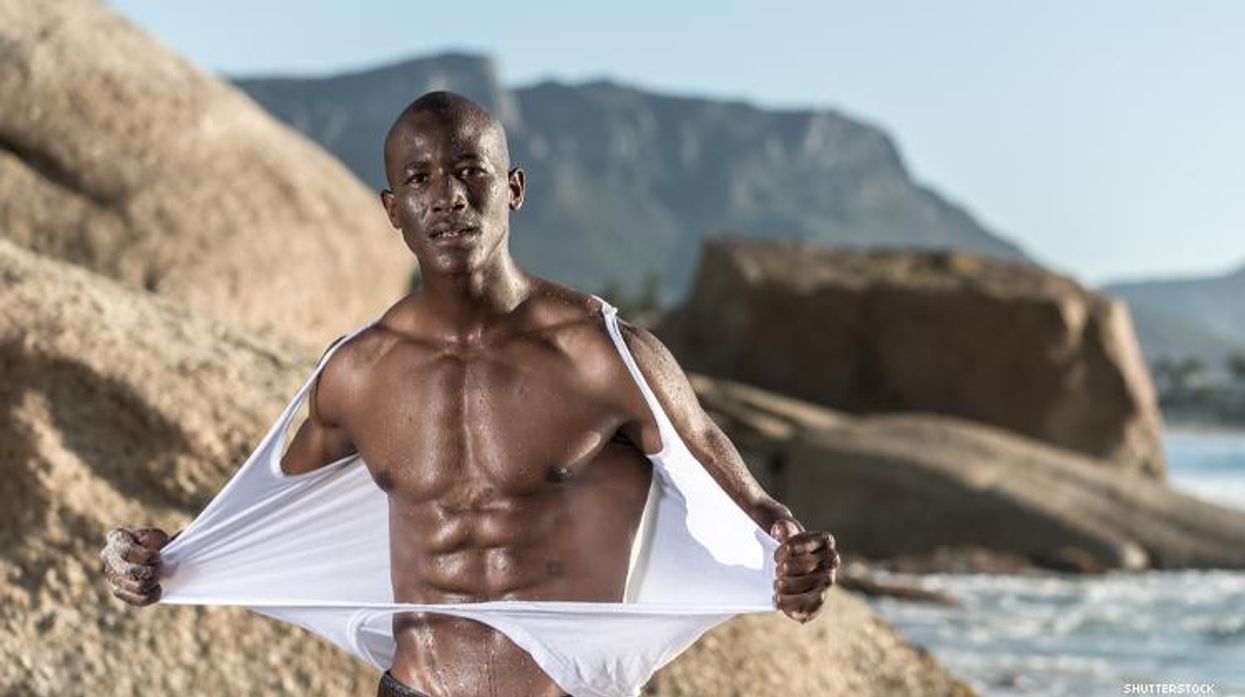 Black man rips off shirt on beach