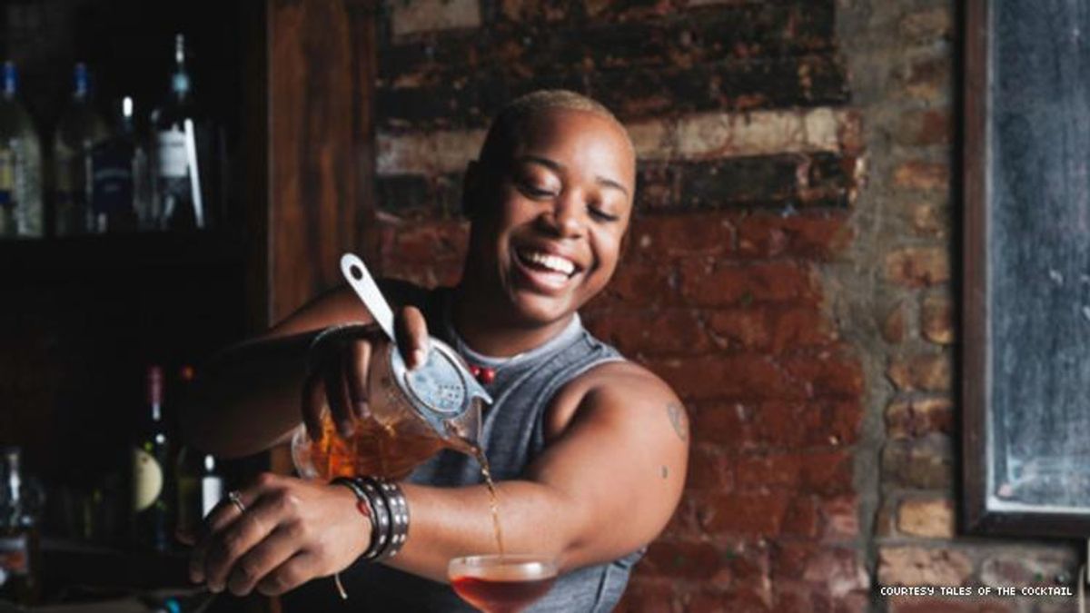 Black mixologist Tiffanie Barriere pours a cocktail