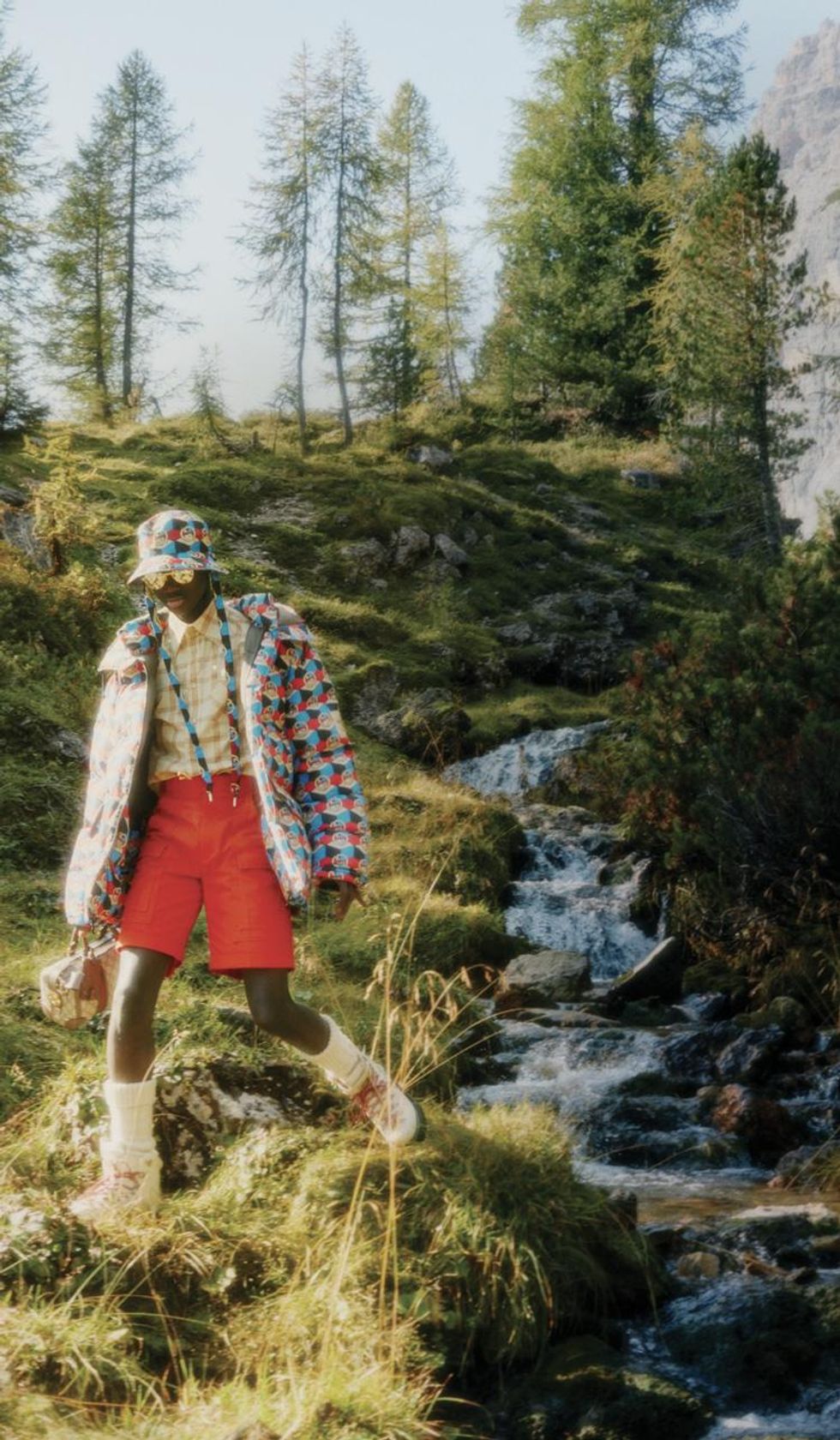 Black model wearing North Face x Gucci outfit next to stream