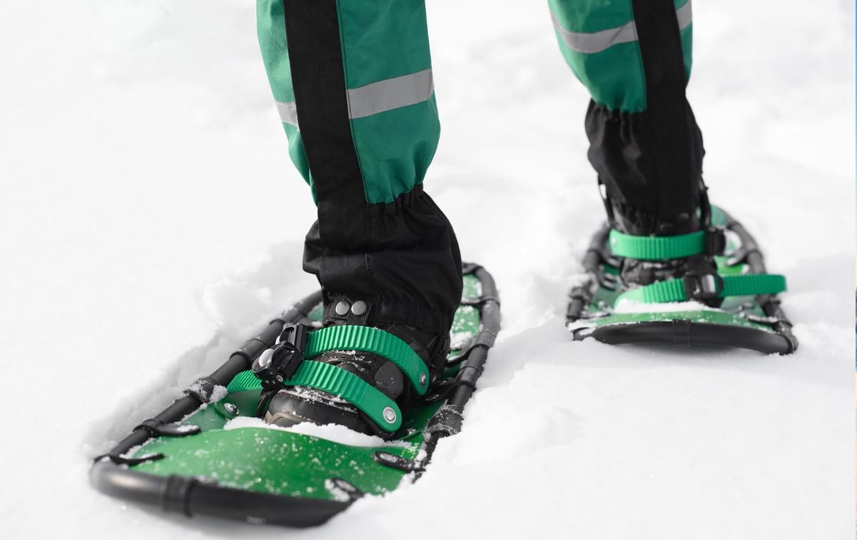 green snowshoes and someone wearing gaiters