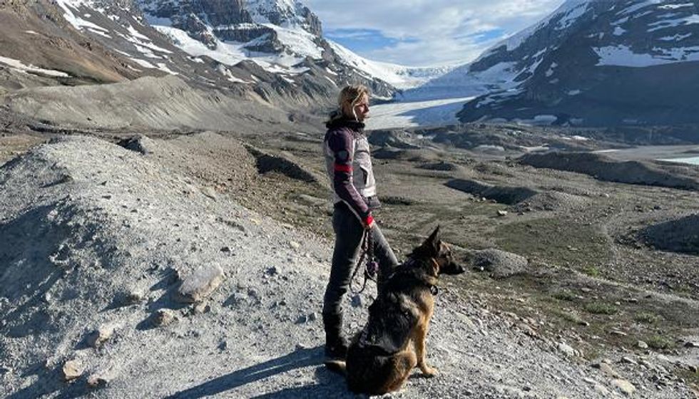Jess Stone with German Shepard Moxie near glacier
