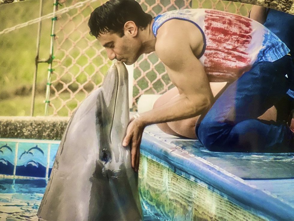 Joey Amato kissing dolphin at Institute of Marine Mammal Studies