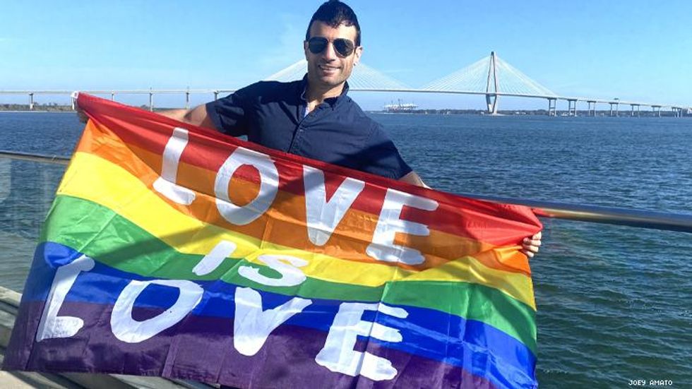 Joey Amato with a Love is Love flag at CHarleston's waterfront