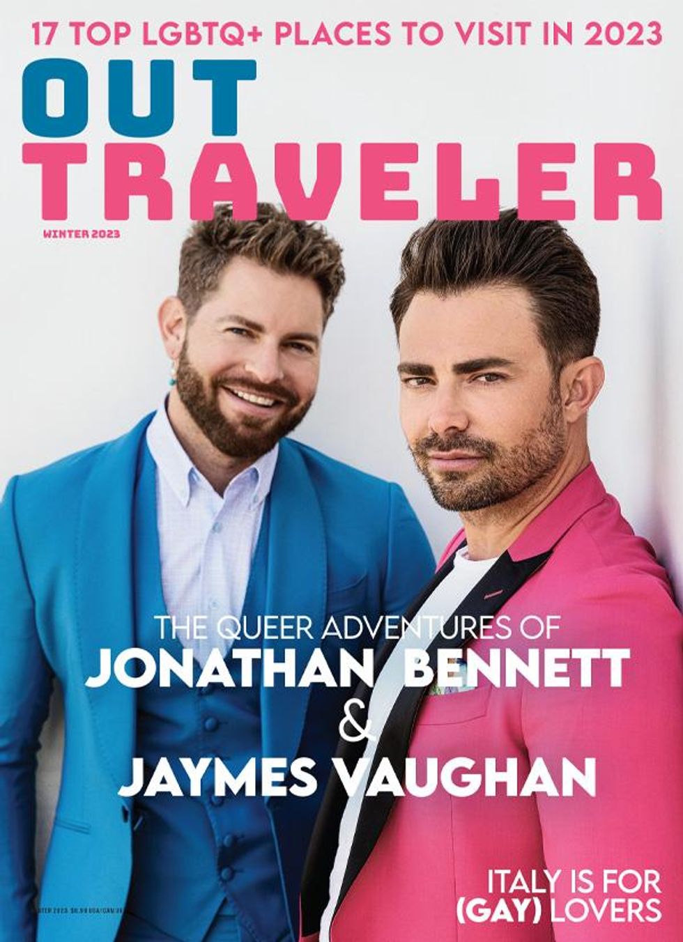 Jonathan Bennett in pink suit and Jaymes Vaughan in blue suit on the cover of Out Traveler Winter 2023.