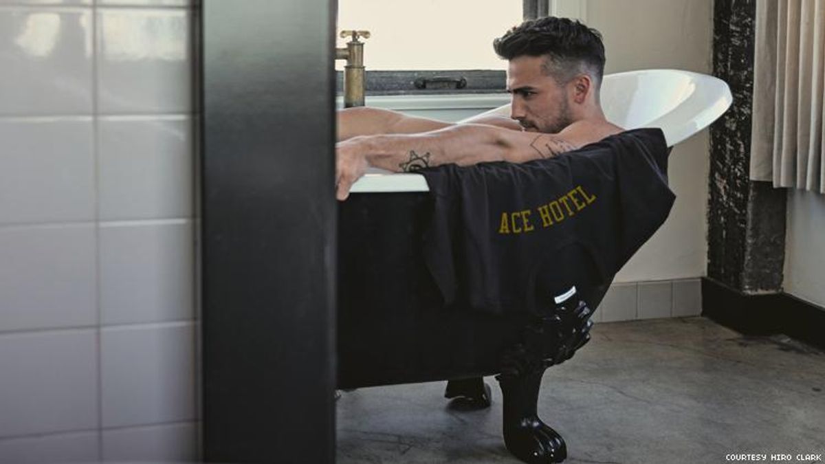 Man in bathtub at Ace Hotel with an Ace branded t-shirt