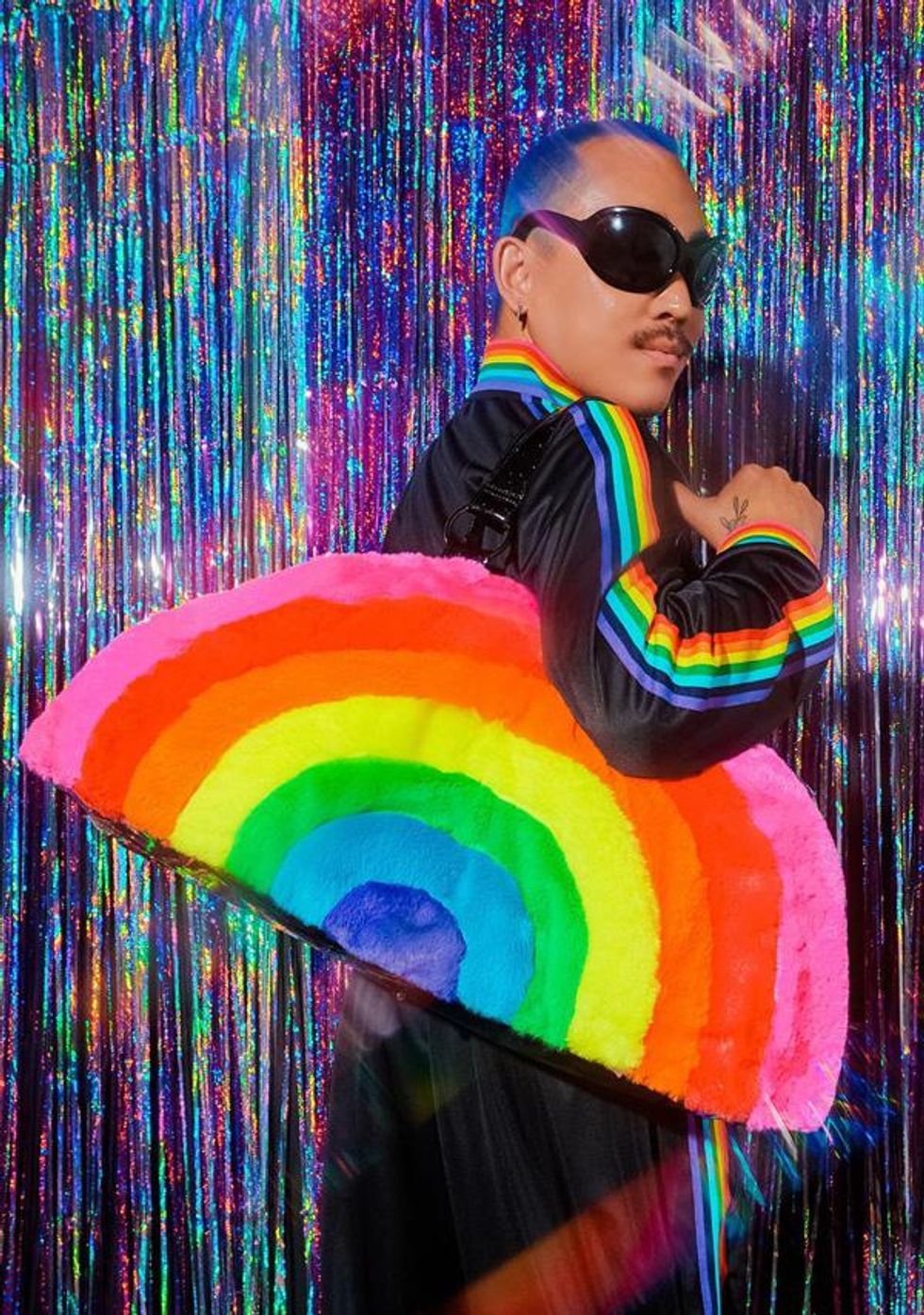 man wearing sunglasses and rainbow bag over shoulder