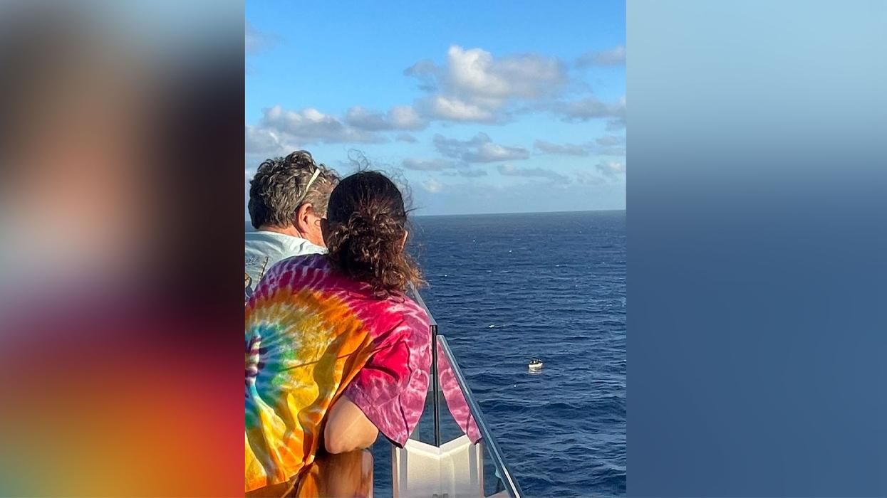 migrant boat dwarfed by the cruise ship it was photographed from