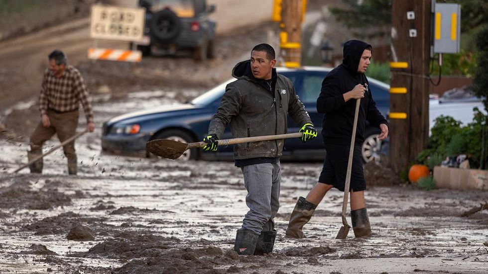 Residents work to push back wet mud in the small unincorporated town of Piru, east of Fillmore, California