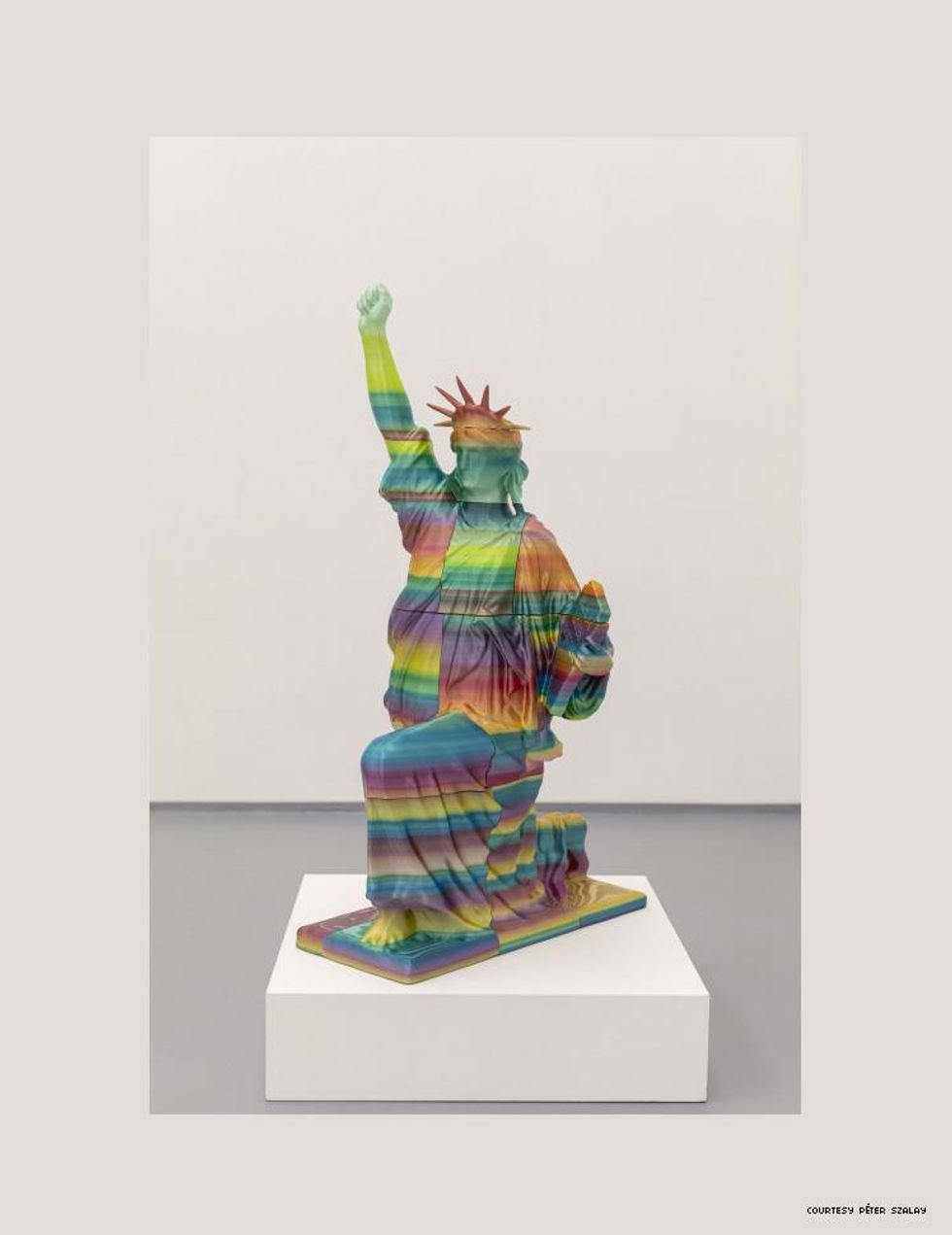 sculpture by peter szalay lady liberty kneeling with fist in air and Black Lives Matter written on her tablet