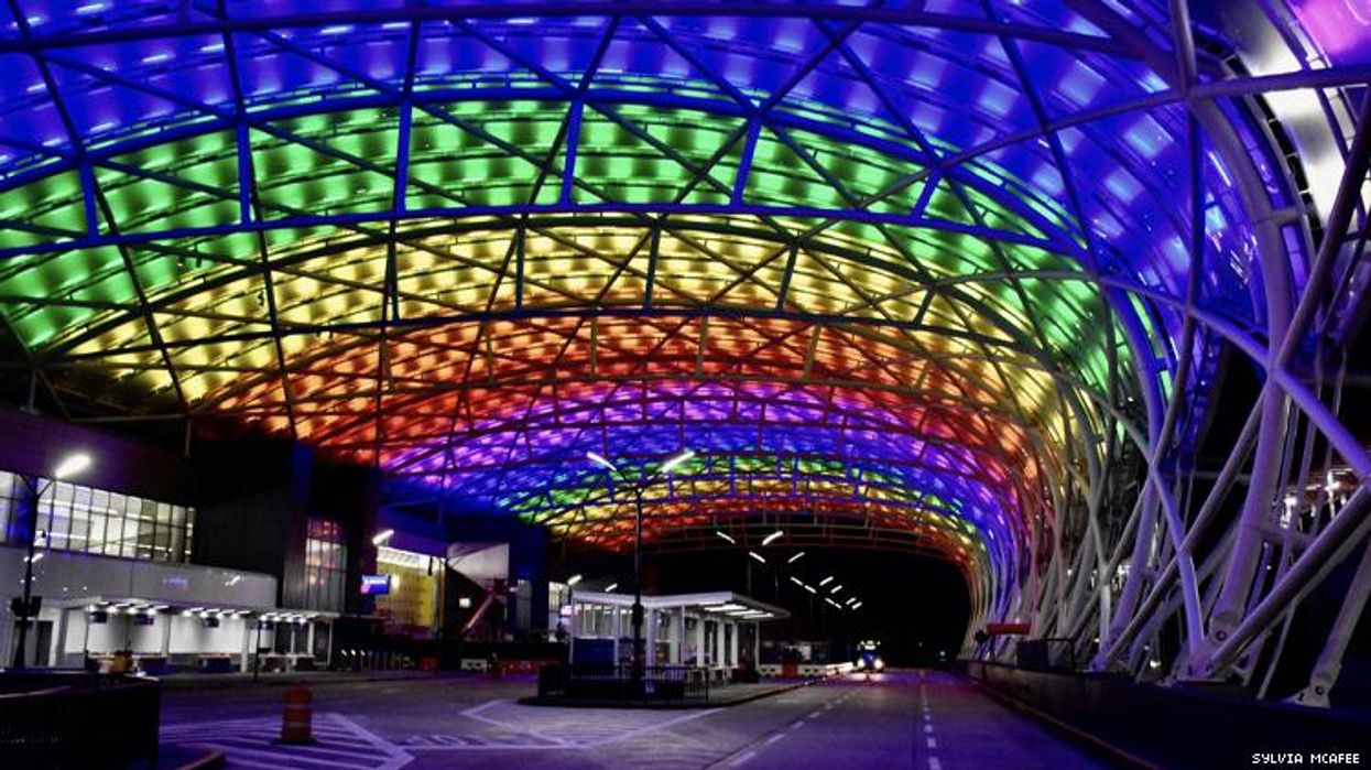 The Atlanta airport at night lit up in rainbow colors to celebrate 50 years of LGBTQ Pride