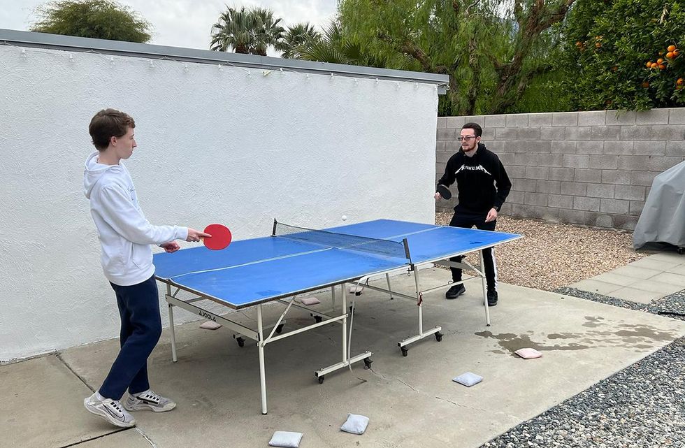 The author\u2019s sons play ping-pong at their Poppy Vacation Rental home