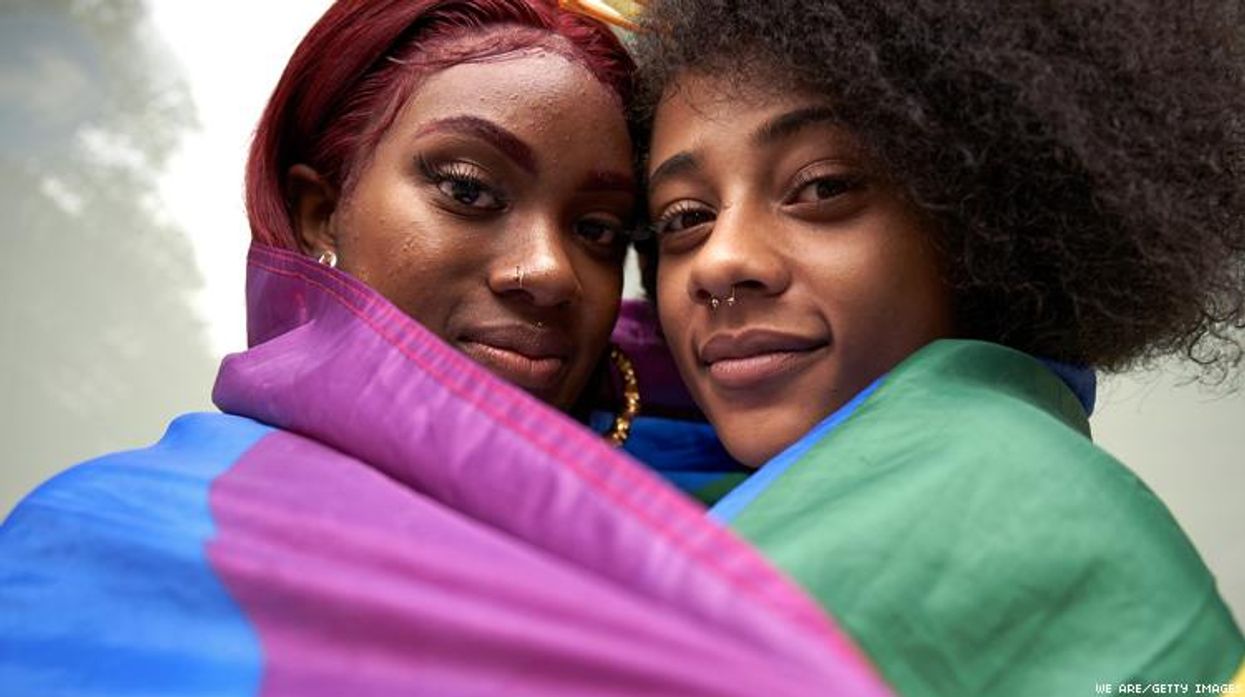 Two Black Lesbians in a Pride Flag