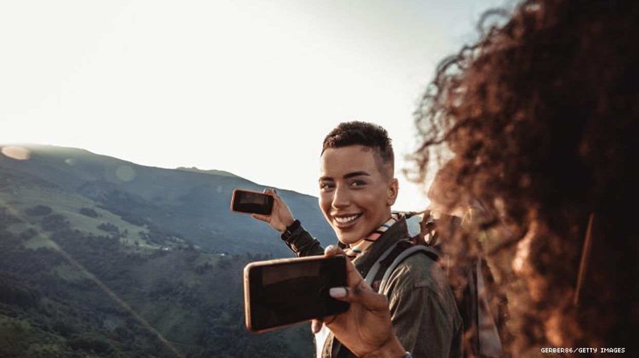 Two Black women on mountain with cell phones