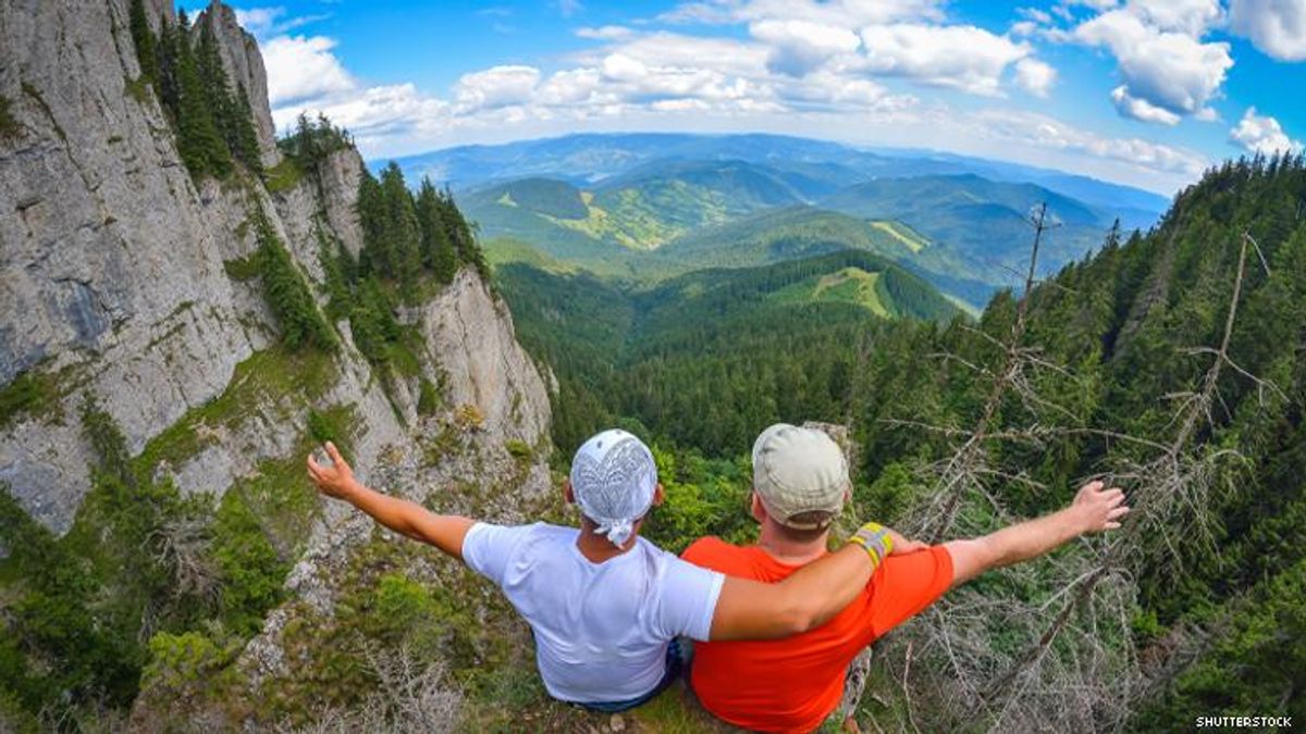 two-young-men-sitting-on-a-cliff-edge-in-the-ceahlau-mountains-in-romania