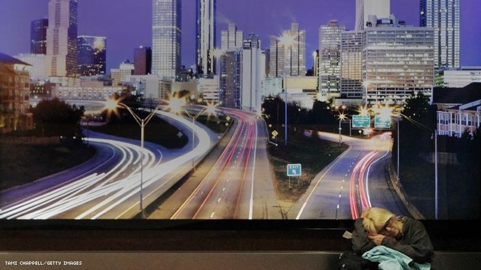 Woman sleeps in Atlanta airport under picture of the city