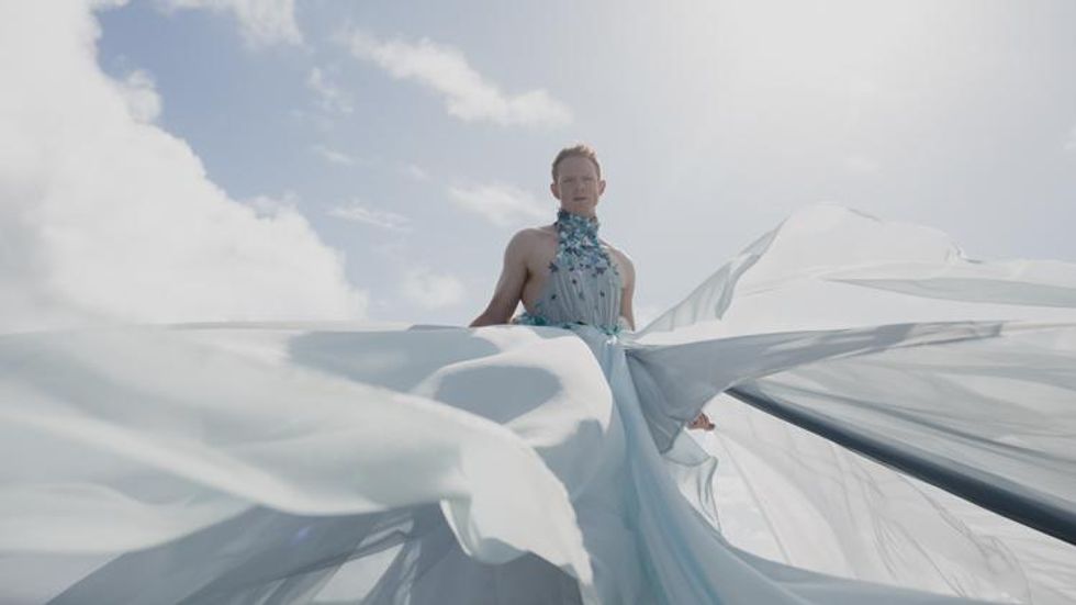 Wyn Wiley as Pattie Gonia in billowing white on Hawaii beach