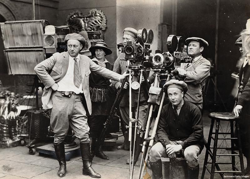 Cecil B. DeMille (hand on hip) directing one of his early motion pictures