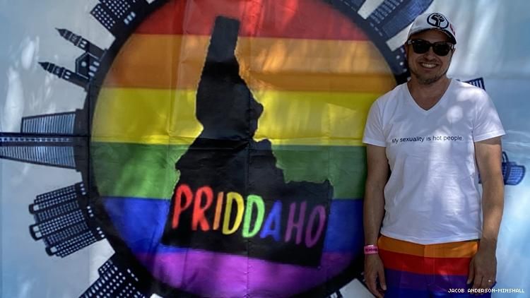 Jacob Anderson-Minshall at Pocatello Pride 2021 in front of Priddaho Sign