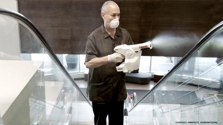 A worker at Marriott uses an electrostatic cleaner 