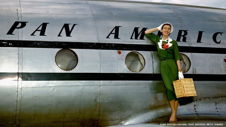 Vintage photo of silver Pan American Airways plane with stewardess standing on wing