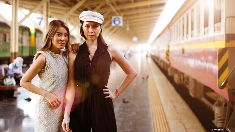 Lesbian Asian couple, one of whom is a trans woman, on train platform