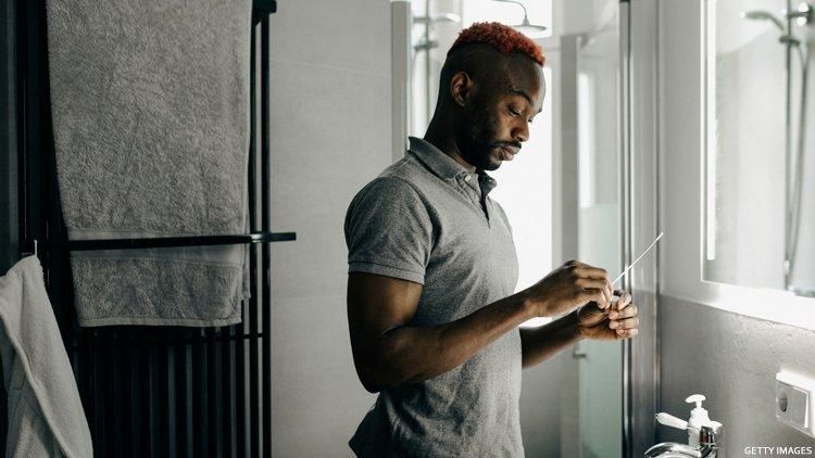 Black man takes a home COVID test