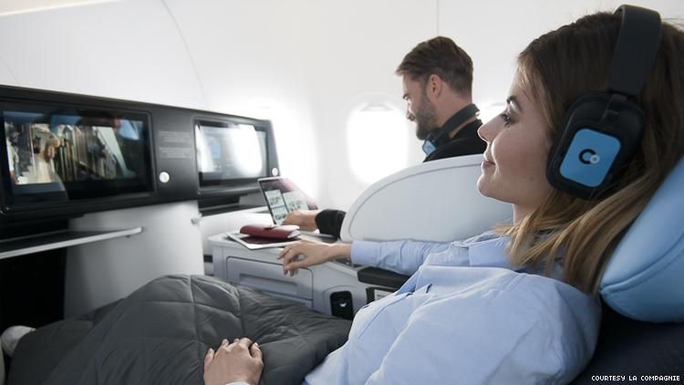 la compagnie airline cabin with woman reclined in seat