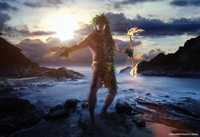 Native Hawaiian man holding a torch on a beach