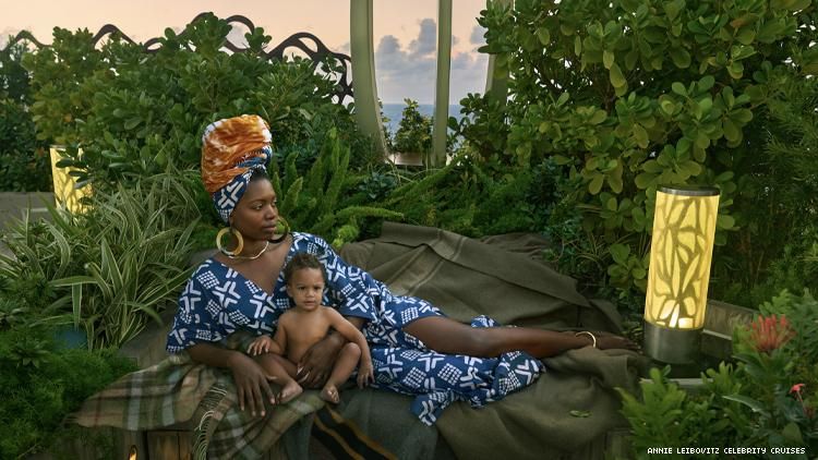 Paola Mathé in African inspired clothing poses with child in garden