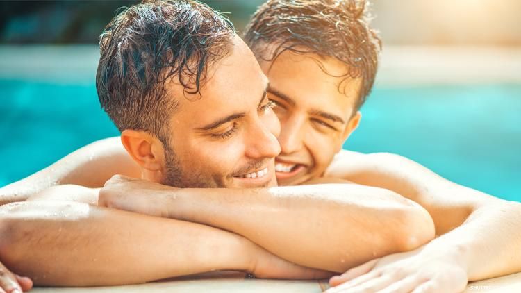 Gay couple embrace in a pool 